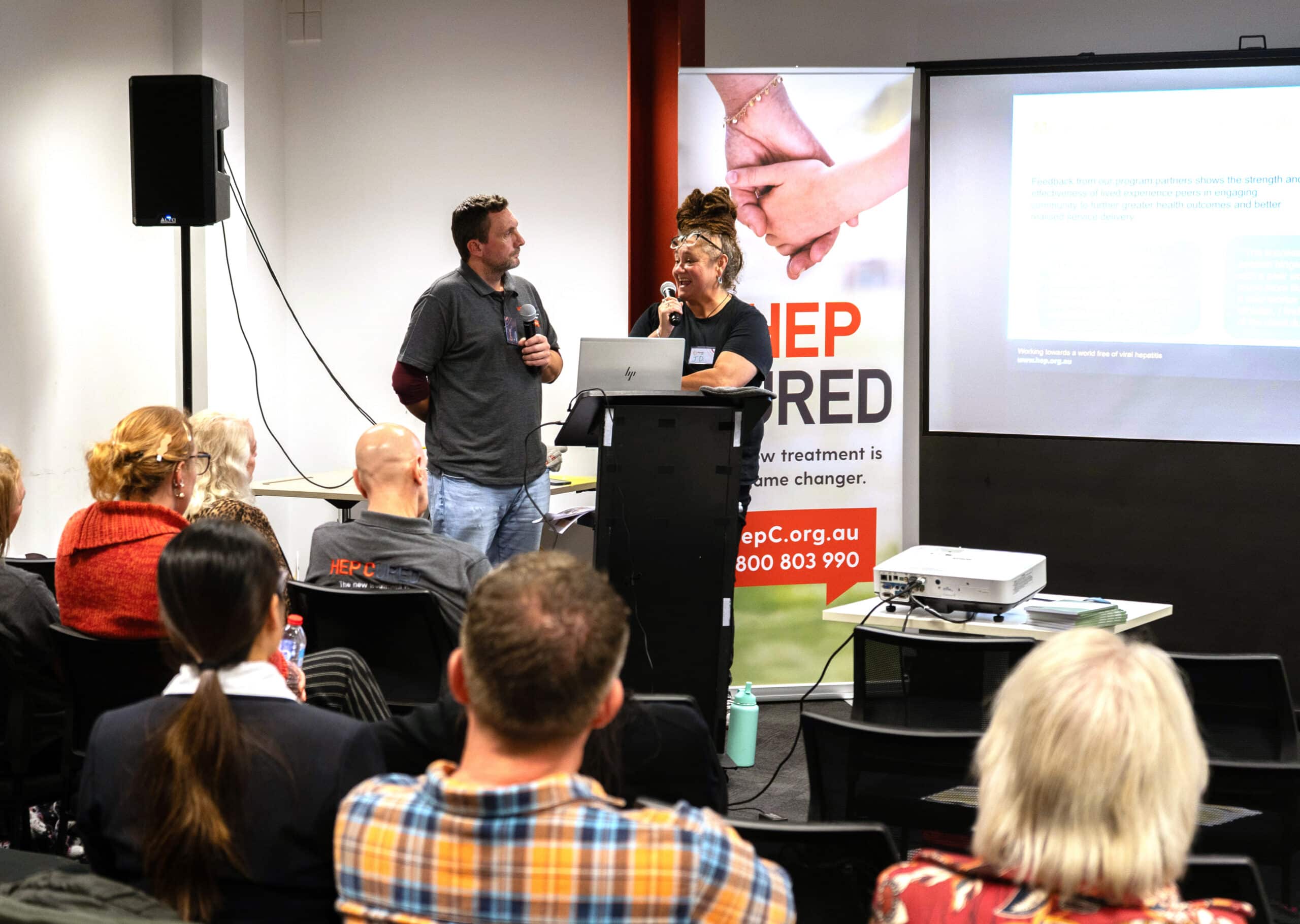 Two people speak at a lecturn